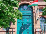 a large blue door with a flag on top of it