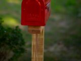 a red mailbox on a wooden post