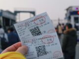 person holding two white tickets