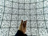 person holding clear glass ball with QR code background