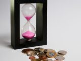 clear hour glass with coins