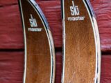 a pair of skis sitting on top of a wooden wall