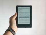 person holding black e book reader