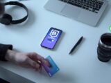 Person holding credit card by digital currency app, exploring blockchain technology.