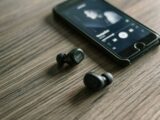 pair of Bluetooth earphones beside phone