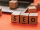 Wooden blocks spelling SEO on a laptop keyboard convey digital marketing concepts.