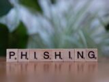 Wooden tiles spelling 'phishing' highlight cybersecurity themes.