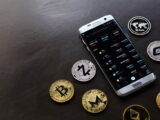 A collection of cryptocurrency coins and a smartphone displaying a digital trading platform.