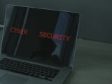 Close-up of a laptop displaying cybersecurity text, emphasizing digital security themes.