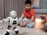 A young boy interacts with a programmable robot in a cozy living room setting.
