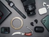 Flat lay of tech gadgets and personal accessories including camera and smartwatch.
