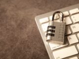 A padlock rests on a computer keyboard.