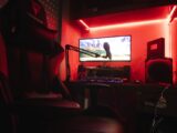 Sleek gaming setup featuring a microphone, neon lights, and a gaming chair in a home studio.