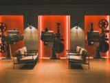 A cozy retro cinema room showcasing vintage film projectors and comfortable seating.