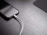 black smartphone with charger cord connected