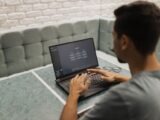 A man working on a laptop in a cozy, modern office space with a focus on technology.