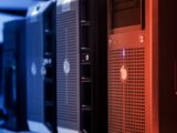 Close-up of tower servers in a data center with blue and red lighting.