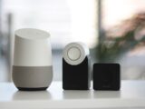 white and gray Google smart speaker and two black speakers