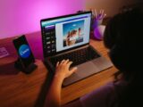 Teen working on graphic design using laptop at home with creative tools.