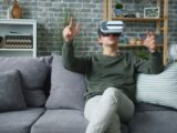 A young man using a VR headset on a couch, enjoying a virtual reality experience.