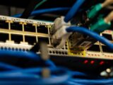 Close-up image of ethernet cables plugged into a network switch, showcasing IT infrastructure.