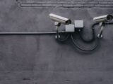 two bullet surveillance cameras attached on wall