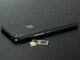 Close-up of a smartphone with a SIM card and memory card, showcasing modern technology.