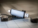 High-quality close-up of a dual USB-C and USB-A flash drive on a sleek grid-patterned background.