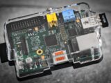 Detailed image of a Raspberry Pi microcomputer circuit board in a clear case.