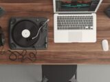 Top view of a music production desk with a laptop and turntable setup for modern audio production.
