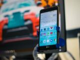 LG smartphone securely mounted in a car holder indoors, displaying various apps on the screen.