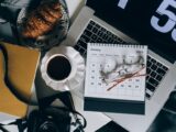 A serene workspace setup with coffee, croissant, laptop, and calendar, ideal for organizing plans.