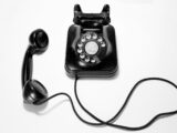 black rotary dial phone on white surface