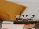 club master eyeglasses on pile of three books