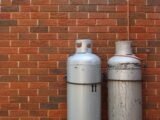 a couple of white bottles next to a brick wall