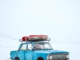 blue sedan on snow ground