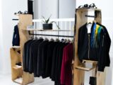 assorted clothes hanged on brown wooden rack