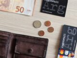 50 euro and coins on white wooden table