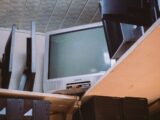 A room with two televisions and a keyboard