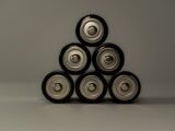 Metallic AA batteries stacked in a pyramid shape, symbolizing power and energy storage.