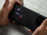 A person holding a cell phone with a game on it