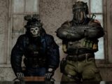 Two soldiers in tactical gear standing indoors.