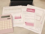 Bills, calculator, and a laptop: financial tasks underway.