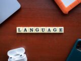 the word language spelled with scrabble tiles on a table