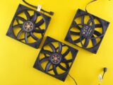 Three black computer cooling fans arranged on a vivid yellow backdrop, perfect for tech themes.