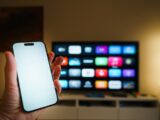 Smartphone held in front of a smart TV screen