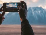 person holding black smartphone taking photo of mountain during daytime