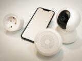 A cell phone and a camera sitting on a table