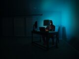 man siting facing laptop