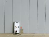 A smartphone displaying an ecommerce site with a credit card, set on a wooden surface, depicting online shopping.